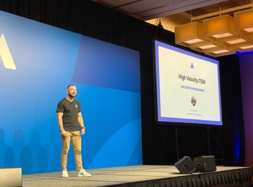 Atlassian High Velocity ITSM keynote — presenting the Domino's expansion story.